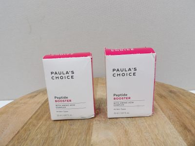 two boxes of paula ' s choice products sitting on top of a wooden table
