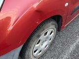 a small red car parked on the side of the road
