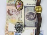 a lot of money and a watch sitting on a table