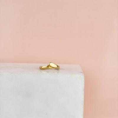 a close up of a gold ring sitting on top of a white block