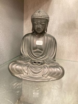 une statue de Bouddha assis sur une table en verre