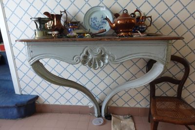 a small table with a vase on top of it and a chair in front of it