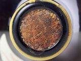 a close up of a bottle of wine with a rusted top