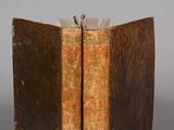 two old books sitting on top of each other on a table