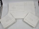 Plusieurs serviettes blanches sont posées sur une table, à côté d'une paire de ciseaux