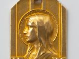 Gros plan sur une médaille d'or portant le visage d'une femme