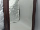 un miroir posé sur le sol à côté d'un mur