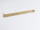 a close up of a gold chain bracelet on a white background