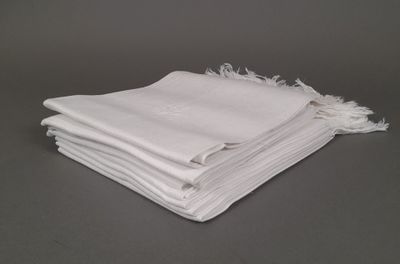 plusieurs serviettes blanches empilées les unes sur les autres sur une table