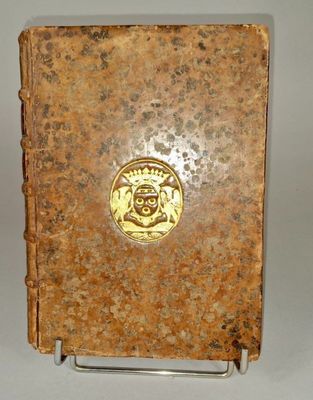 un vieux livre orné d'un médaillon doré