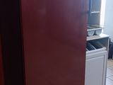 un réfrigérateur rouge dans une cuisine au sol carrelé