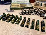 many pairs of scissors sitting on a table next to a pair of glasses