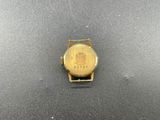 a close up of a gold watch on a black surface