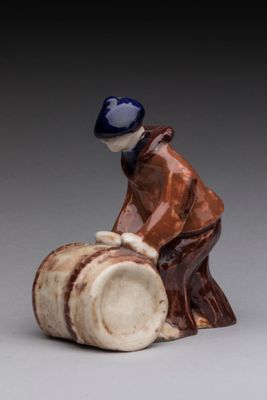 an image of a figurine of a man sitting on a barrel