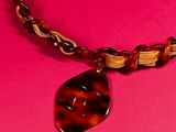 a close up of a necklace on a pink surface