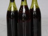 three bottles of wine are lined up on a marble surface