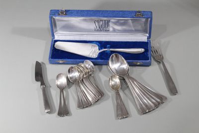 un service d'argenterie dans un coffret bleu posé sur une table