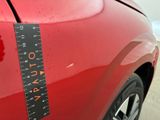 a close up of a red car with a measuring tape on it