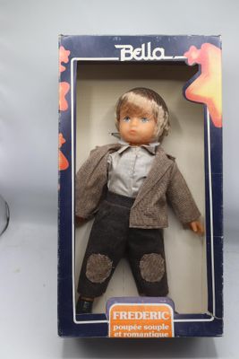 une poupée Barbie dans une boîte sur laquelle figure la photo d'un garçon en costume