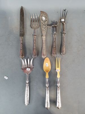 beaucoup d'argenterie sur une table avec des cuillères et des fourchettes
