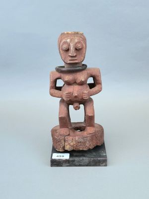 un gros plan sur la statue d'une personne assise sur un rocher
