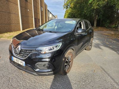 une voiture noire garée sur le bord de la route, à côté d'un immeuble