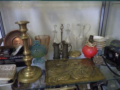 a glass shelf with a lot of antique items on it