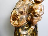une statue de femme tenant un bébé dans ses bras