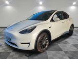 a white tesla suv parked on a checkered floor in a garage