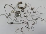 a lot of silver jewelry on a white surface