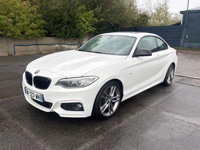 La BMW M140i blanche est garée sur un parking.