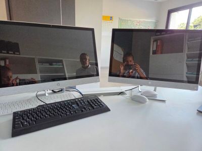 deux écrans d'ordinateur posés sur un bureau avec un clavier et une souris