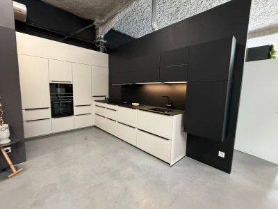 une cuisine en noir et blanc avec des placards blancs et une cuisinière noire