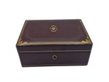 a brown leather box with gold trimming on the lid