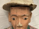 a statue of a man wearing a hat and vest
