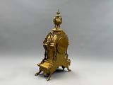 une horloge en or posée sur un socle