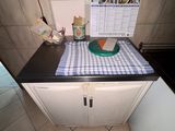 une petite cuisine avec une nappe à carreaux posée sur le plan de travail