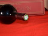 a bottle of wine sitting on a table with a red cloth