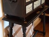a black and white chest of drawers on a wooden table
