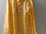 une chemise jaune suspendue à un cintre accroché au mur d'une pièce