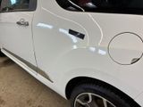 a small white car that is parked in a garage