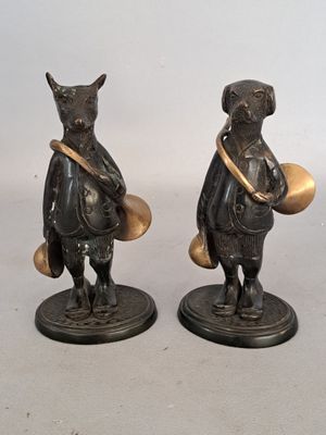 two figurines of animals that are standing next to each other