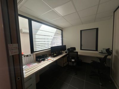 un bureau équipé d'un ordinateur et d'un écran, dans une pièce