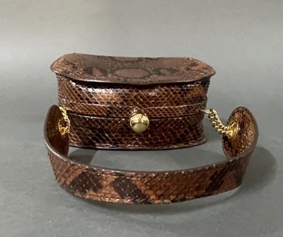 brown snake skin purse with gold chain strap on grey background