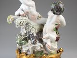 une figurine ancienne représentant deux chérubins, posée sur un socle en or