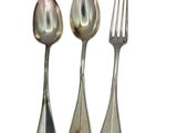 three spoons and a fork sitting next to each other