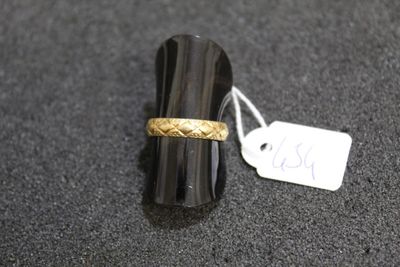 a ring with a gold band sitting on top of a black surface