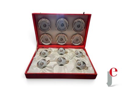 un coffret rouge contenant six tasses argentées et blanches