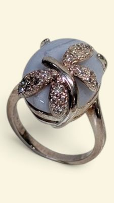 silver ring with blue stone and brown diamonds on it