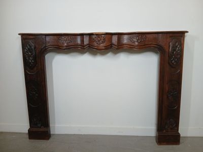 a wooden fireplace surround with carvings on the top of it